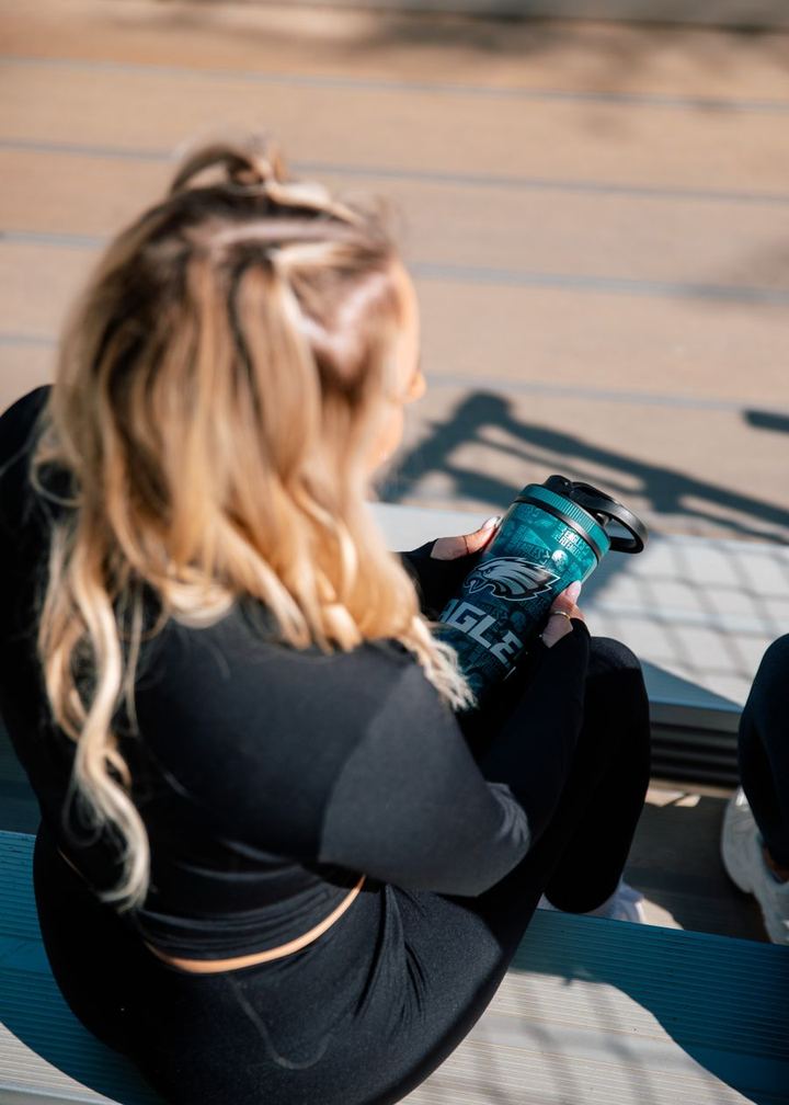 Fan holding a Philadelphia Eagles 4D Ice Shaker on the bleachers