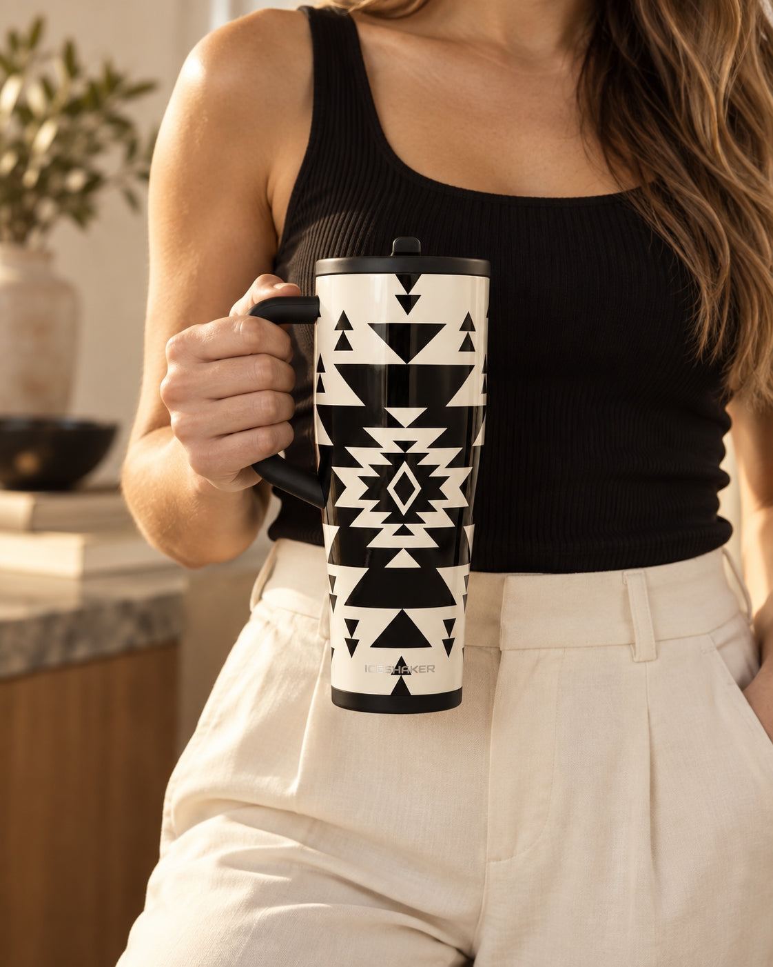 Woman holding the Ritual tumbler by its handle in a sunlit kitchen